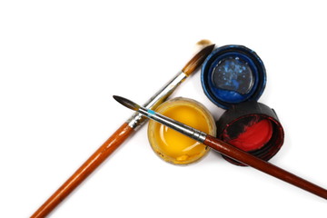 Multicolored watercolor bottle containers with paintbrush isolated on white background, top view