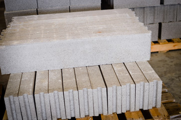 Motion blur image of cement building blocks stacked piled in warehouse background, closeup fabric plant manufacture grey textured abstract surface
