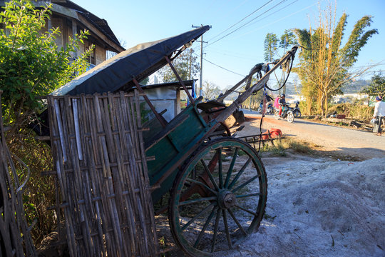 Kalaw, Myanmar - February 8, 2018: Old wooden rickshaw sits idle by the side of the road