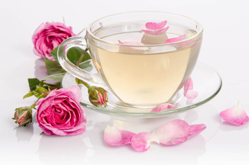 Glass cup of Tea with roses and petals