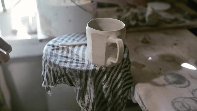 Closeup potter finished cup which stand on potter wheel