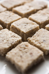 Barley water in glass bowl with spoon and raw and cooked pearl barley wheat/seeds. selective focus