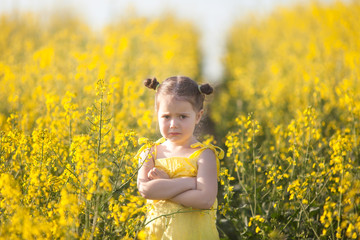 Fototapeta premium Sad girl in rape seed field