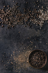 Variety of different black peppers allspice, pimento, monks pepper, peppercorns and ground powder...