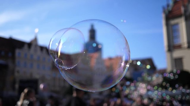 Slow motion fly of a big soap bubble in a city center public place in Wroclaw Poland