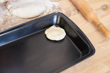 Black pan. Raw dough. Cooking buns. Delicious recipe