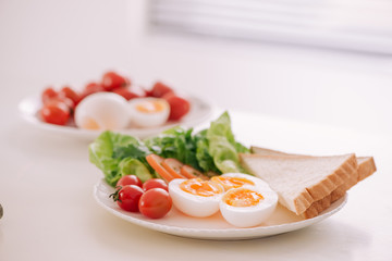 Fresh garden salad with egg, avocado and tomato in brownstone dish for a healthy low calorie lunch.