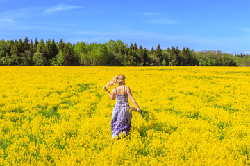 Fototapeta premium Girl running across the yellow field.