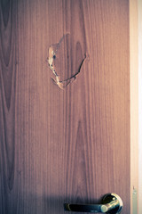 Broken door with golden handle and lock, side view