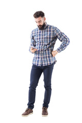 Bearded young Caucasian adult man typing message on mobile phone. Full body isolated on white background. 