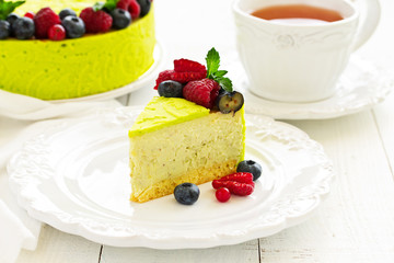 Home pistachio cheesecake with raspberries and blueberries.