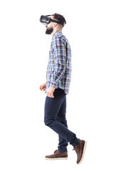 Naklejka premium Profile view of business man watching virtual reality headset walking. Full body isolated on white background. 
