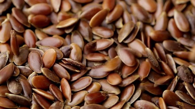 Flax seeds pouring end rotating in slow motion.
