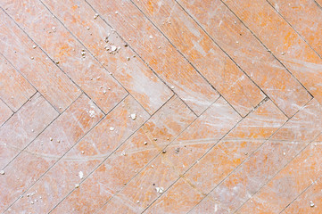 A close-up of an old faded parquet covered with dust and dirt. Result of repair. Cleaning and cleaning required
