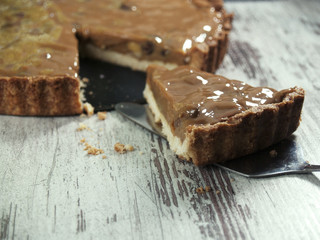 gâteau sur un fond croustillant à la masse de caramel au beurre avec des noix et des amandes