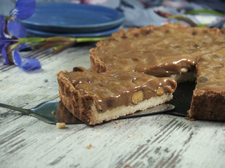 gâteau sur un fond croustillant à la masse de caramel au beurre avec des noix et des amandes