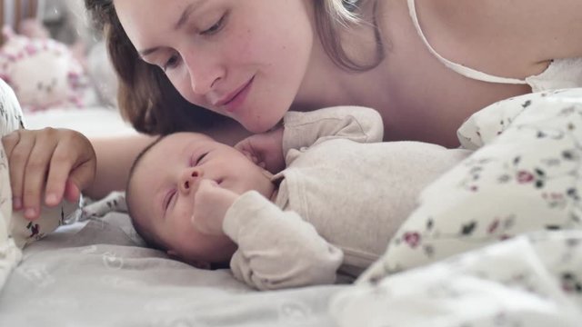 beautiful young mother smile and kiss her newborn child