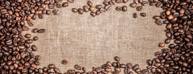 Background with frame of  roasted coffee grains macro close-up on burlap backdrop
