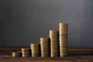 Increasing columns of coins, step of coins stacks on wooden table with copy space for business and financial concept.