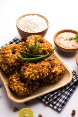 Sabudana vada or Sago fried cake served with peanut chutney over moody background, popular fasting recipe from India. 