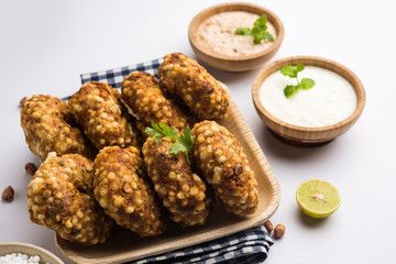 Sabudana vada or Sago fried cake served with peanut chutney over moody background, popular fasting recipe from India. 