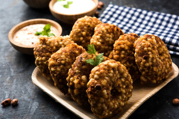 Sabudana vada or Sago fried cake served with peanut chutney over moody background, popular fasting recipe from India. 