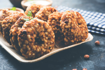 Sabudana vada or Sago fried cake served with peanut chutney over moody background, popular fasting...