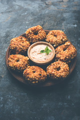 Sabudana vada or Sago fried cake served with peanut chutney over moody background, popular fasting recipe from India. 