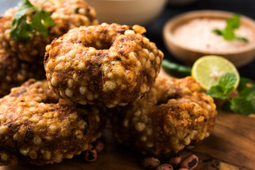 Sabudana vada or Sago fried cake served with peanut chutney over moody background, popular fasting recipe from India. 
