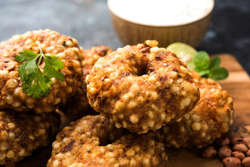 Sabudana vada or Sago fried cake served with peanut chutney over moody background, popular fasting recipe from India. 