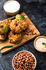 Sabudana vada or Sago fried cake served with peanut chutney over moody background, popular fasting recipe from India. 