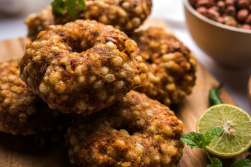 Sabudana vada or Sago fried cake served with peanut chutney over moody background, popular fasting recipe from India. 