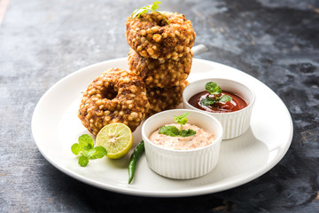 Sabudana vada or Sago fried cake served with peanut chutney over moody background, popular fasting recipe from India. 