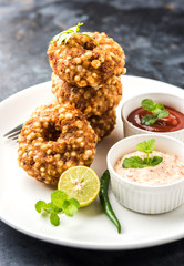 Sabudana vada or Sago fried cake served with peanut chutney over moody background, popular fasting recipe from India. 