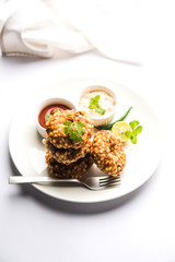 Sabudana vada or Sago fried cake served with peanut chutney over moody background, popular fasting recipe from India. 