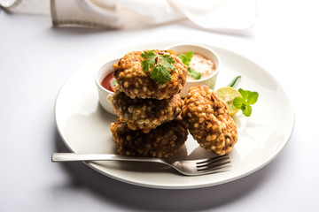 Sabudana vada or Sago fried cake served with peanut chutney over moody background, popular fasting recipe from India. 