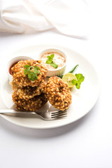 Sabudana vada or Sago fried cake served with peanut chutney over moody background, popular fasting recipe from India. 