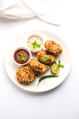 Sabudana vada or Sago fried cake served with peanut chutney over moody background, popular fasting recipe from India. 