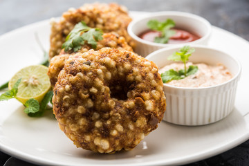 Paneer Butter Masala also known as Panir  makhani or makhanwala. served in a ceramic or terracotta bowl with fresh cream and coriander. Isolated over colourful moody background. selective focus