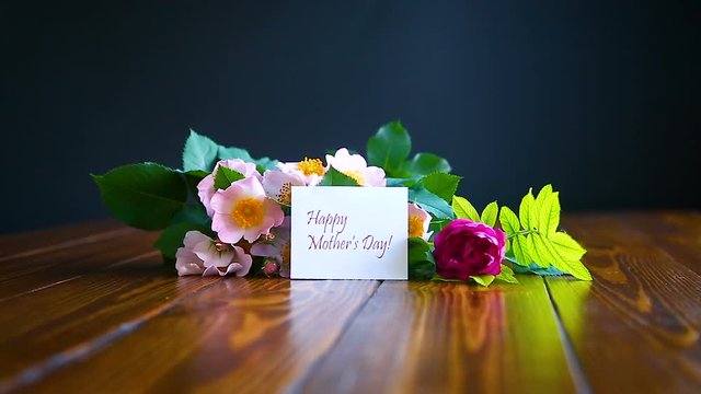 beautiful blooming roses and a greeting card for the mother