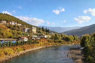 Fototapeta premium Colorful traditional Bhutanese style building decorated with carved wood window frames near the river in Thimphu, Bhutan.