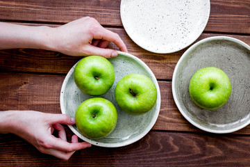 Healthy green food with apples on plates wooden background top v