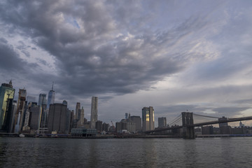 Fototapeta premium Amazing clouds over New York City skyline and Brooklyn Bridge on Hudson river 