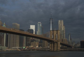 Brooklyn view of Manhattan skyline and Brooklyn Bridge on moody morning