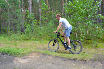Fototapeta na wymiar the athlete goes on a bike ride on a cross-country road.Walking on bike.Healthy lifestyle