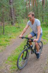 Fototapeta na wymiar the athlete goes on a bike ride on a cross-country road.Walking on bike.Healthy lifestyle