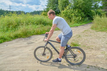 Obraz premium the athlete goes on a bike ride on a cross-country road.Walking on bike.Healthy lifestyle