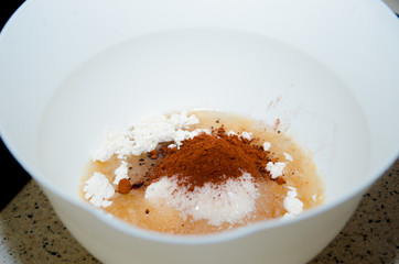 Ingredients mixed for cake, flour, cocoa and sugar are poured into a bowl to prepare cupcakes