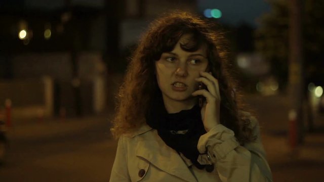 Young woman on the Street talking with her Smartphone. 