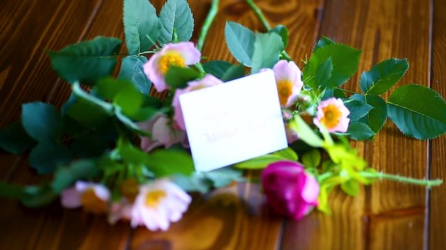 beautiful blooming roses and a greeting card for the mother